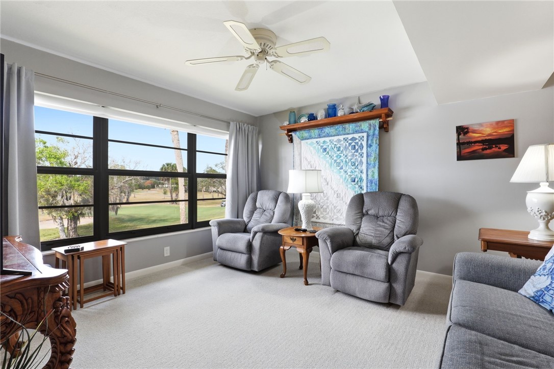 Living area with carpet and a ceiling fan