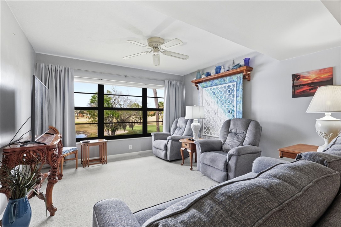Living area with a ceiling fan and carpet