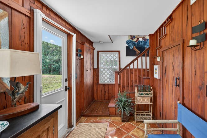 Foyer entrance with wood walls and tile patterned floors