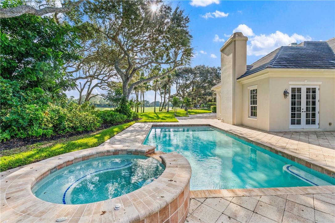 View of swimming pool featuring a patio, a pool with connected hot tub.