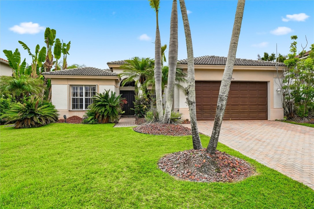 Single-story residence featuring a tile roof, stucco exterior, and a two-car garage with wood-panel doors