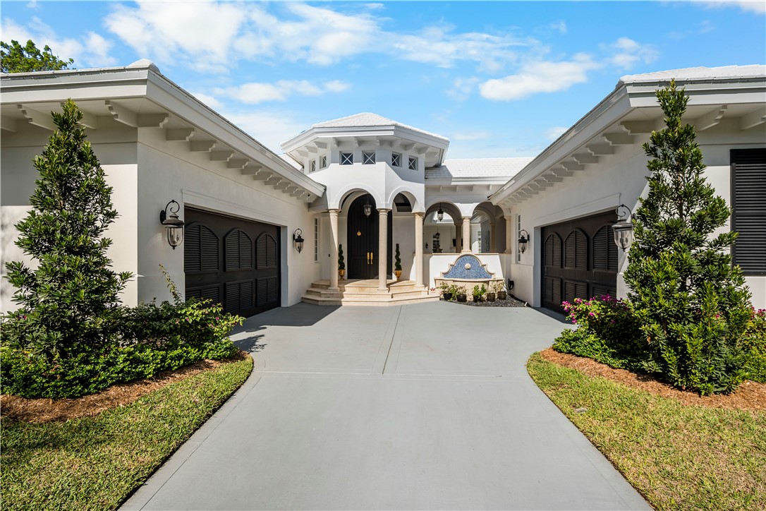 View of front facade with concrete driveway, stucco siding, and an attached garage