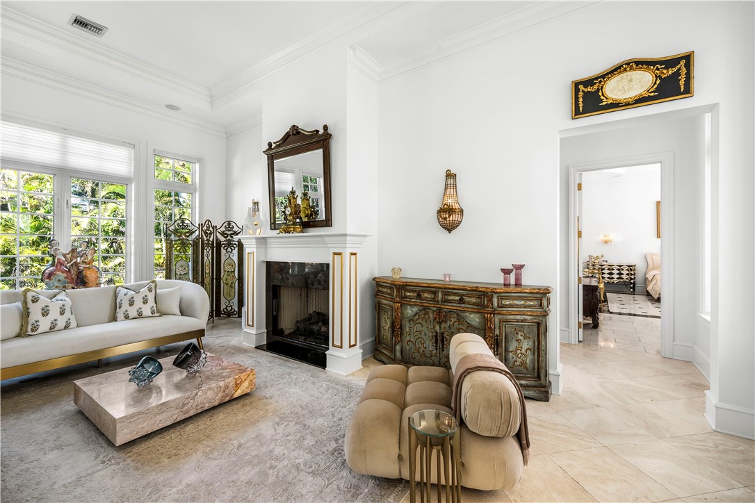 Living room with crown molding and a premium fireplace