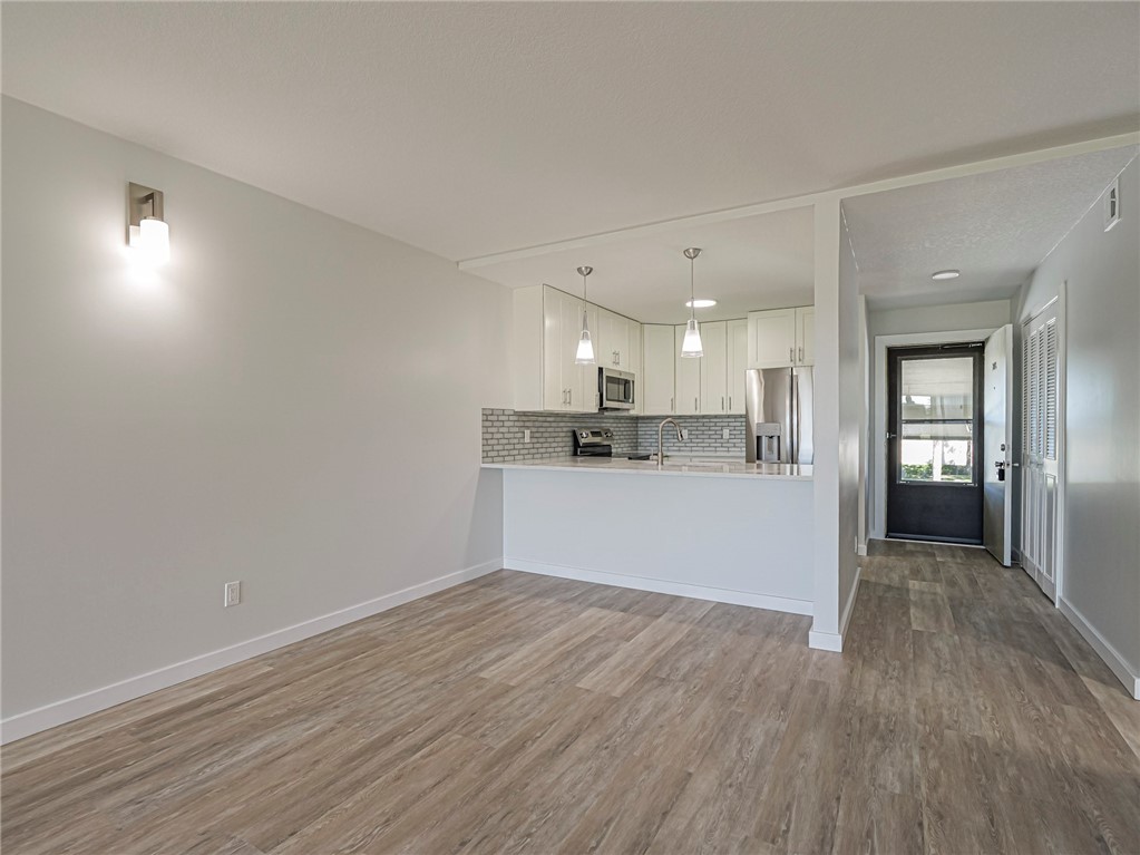 Kitchen featuring new white cabinets w/ soft close system, new hanging light fixtures, open floor plan and new GE stainless steel appliances