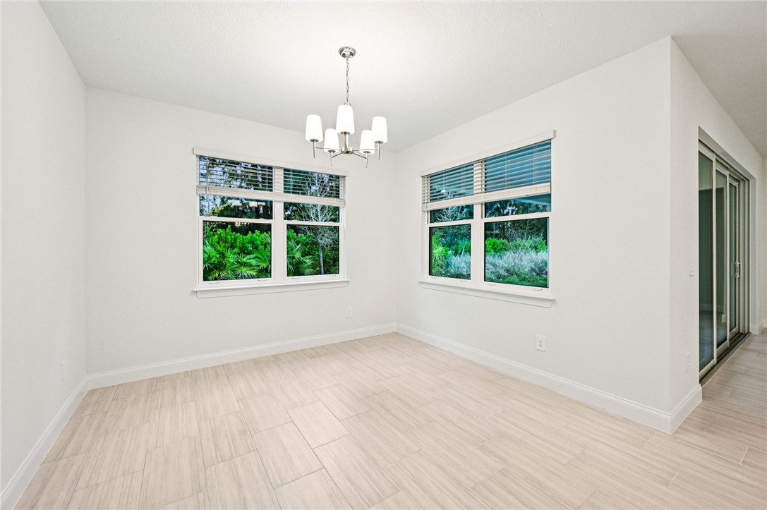 Unfurnished room with a chandelier and wood tiled floors