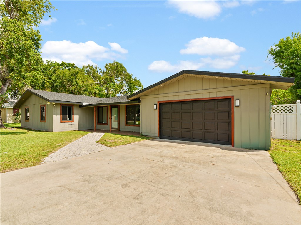 Single story home with concrete driveway, an attached garage, and a shingled roof