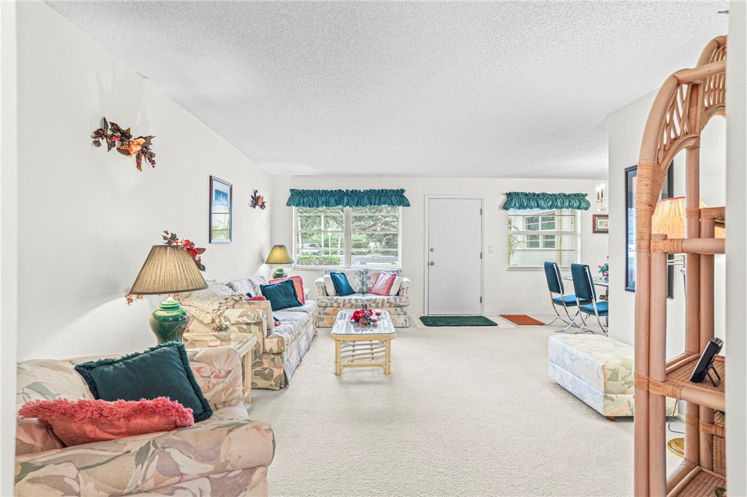 Carpeted living area featuring healthy amount of natural light and a textured ceiling