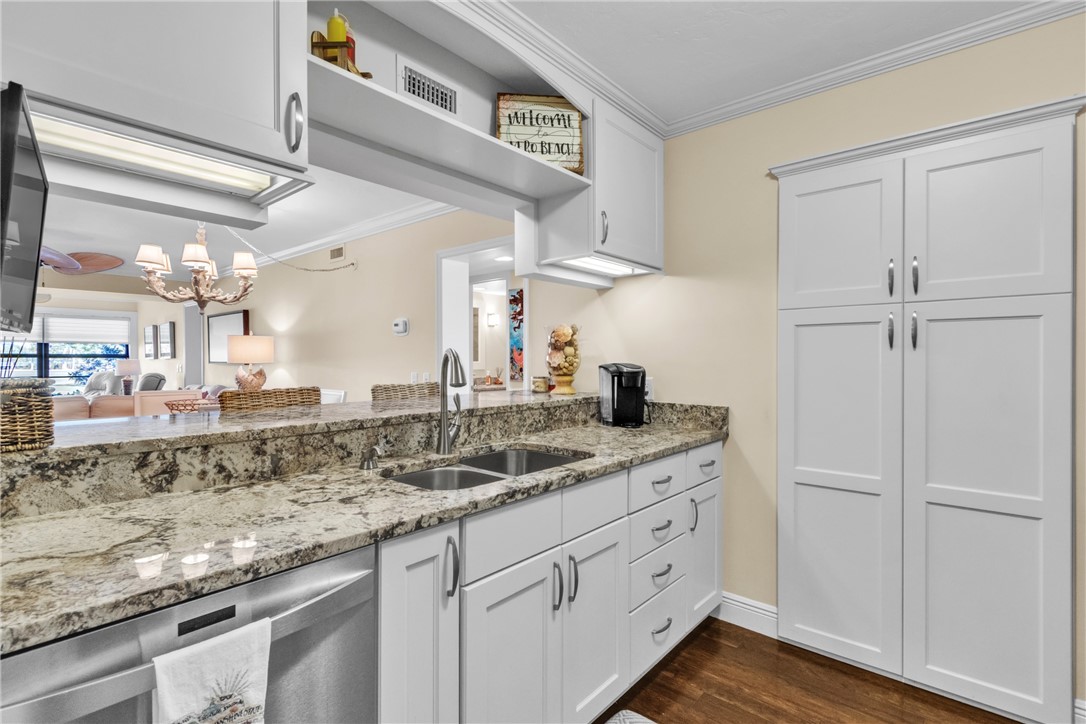 Gorgeous renovated kitchen w/ special pantry door, SS appliances including slide-in range, granite counters, crown molding, tumbled marble backsplash, under counter lighting & engineered wood floors!