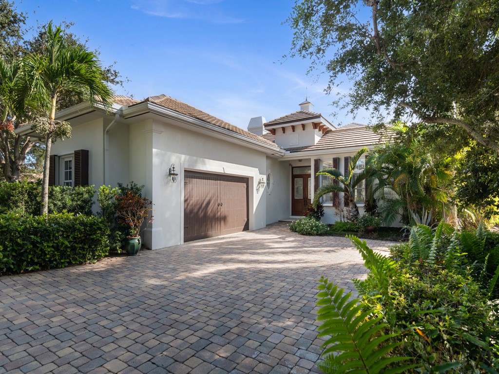 garage, decorative driveway, and a chimney