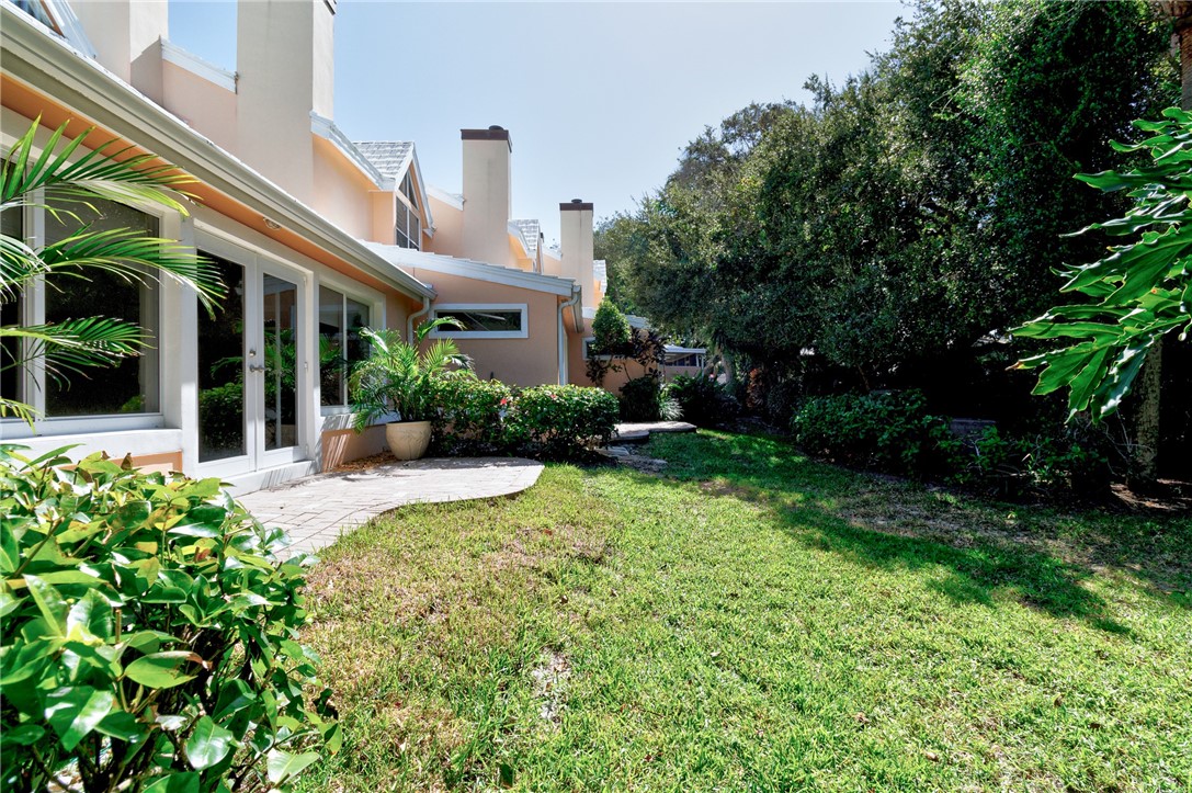 View of green lawn featuring french doors and a patio