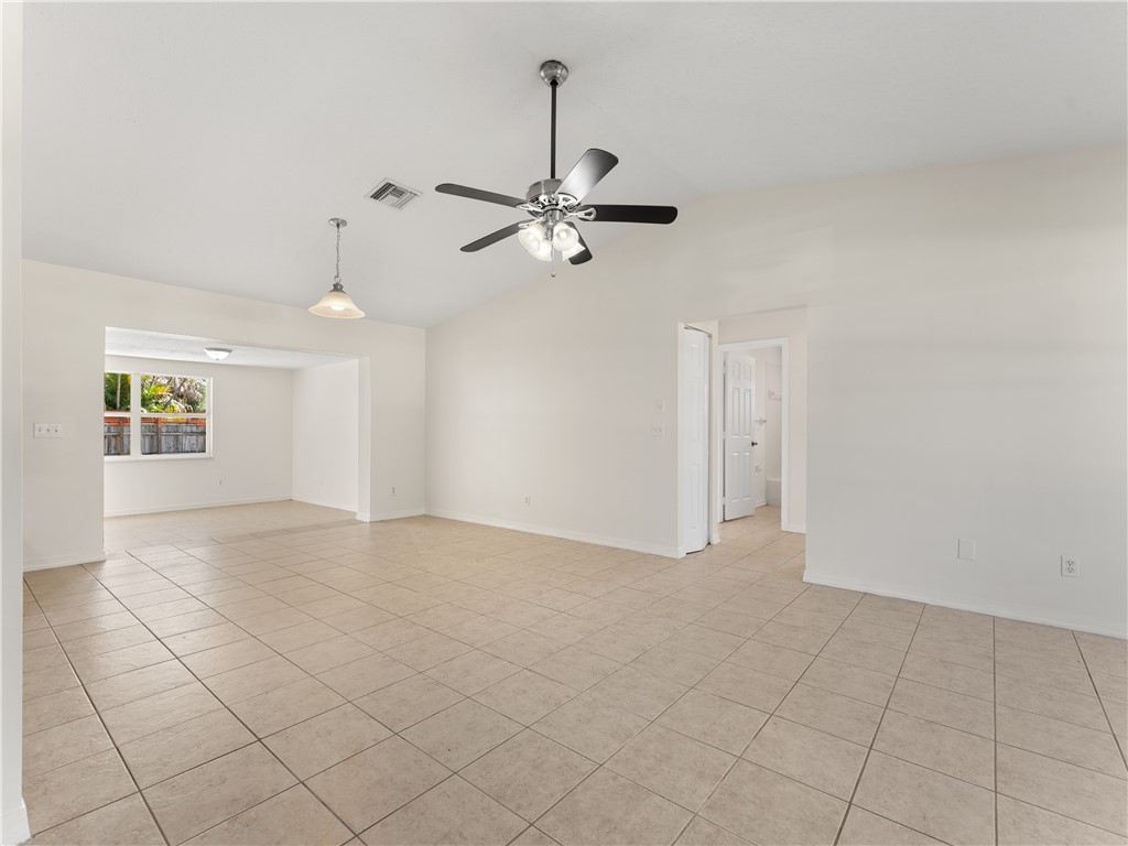 Vaulted ceiling with a ceiling fan, recessed lighting, tile flooring, and white walls