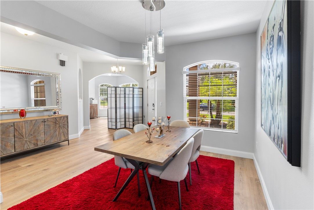 Wood-finish flooring throughout, arched entryway, and a large window with blinds