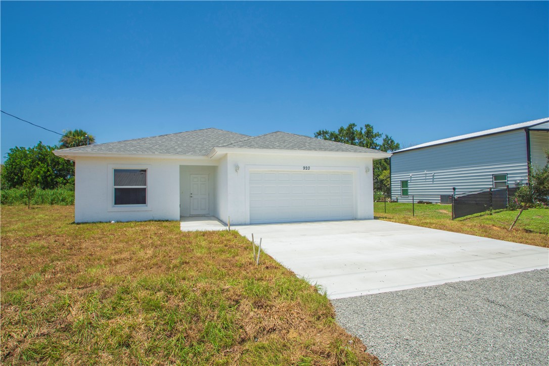 Contemporary single-story residence with a white stucco exterior, attached garage, and a concrete driveway