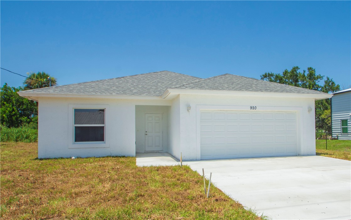 Contemporary exterior with a white stucco finish, a gray shingle roof, an attached two-car garage, and a concrete driveway