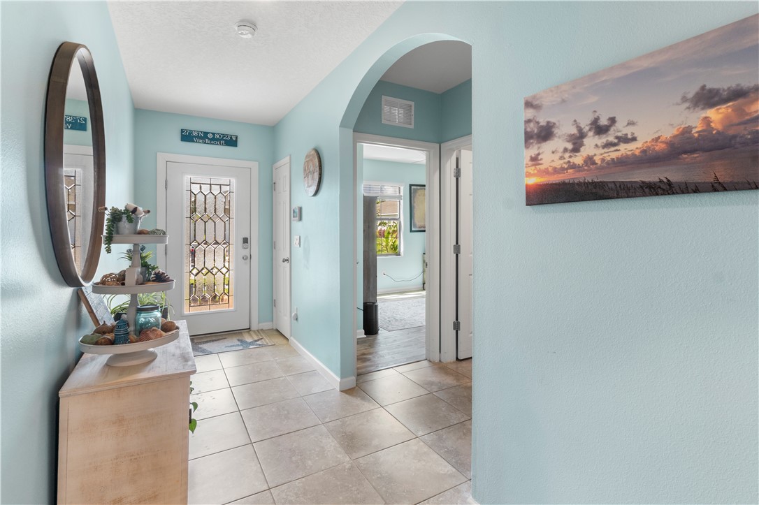 Entryway featuring tile flooring, an arched doorway, and a decorative glass front door