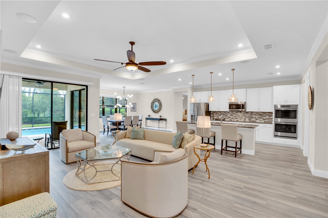 Luxury living with tray ceilings, crown molding, and wood-look plank tile