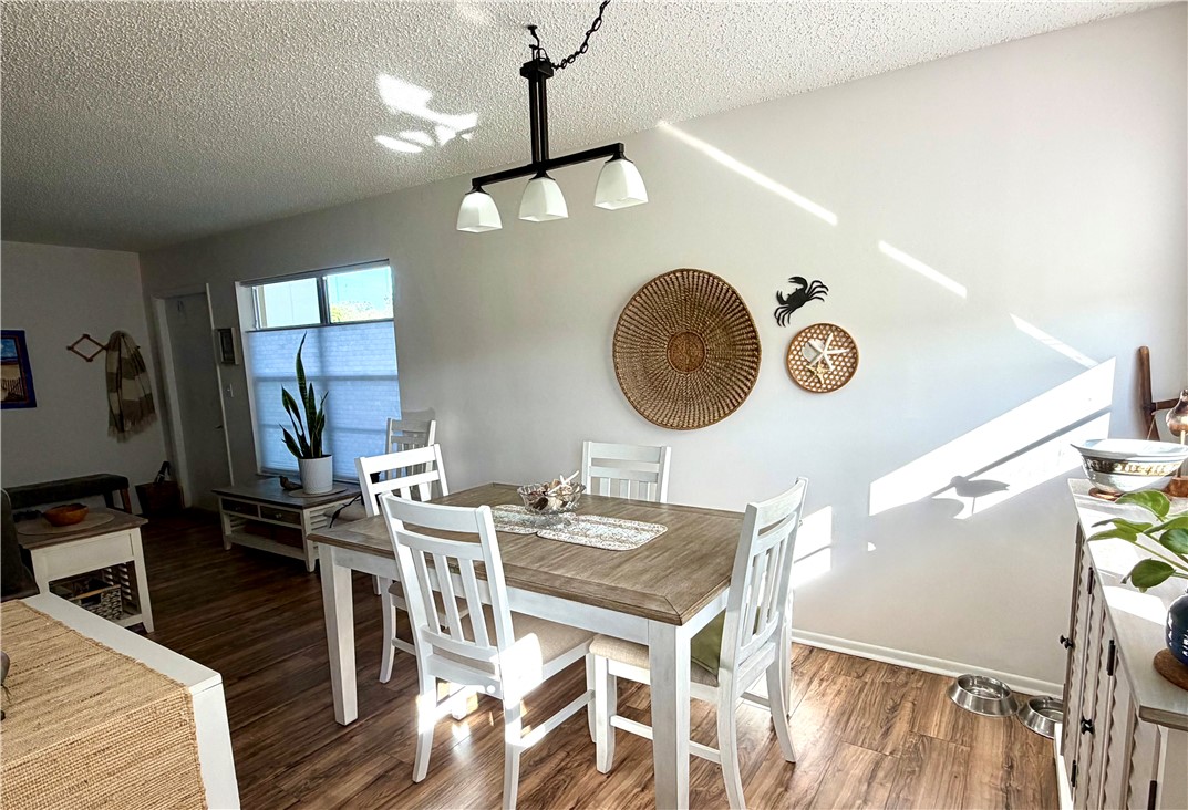 Wood-finish flooring throughout, with a window featuring horizontal blinds