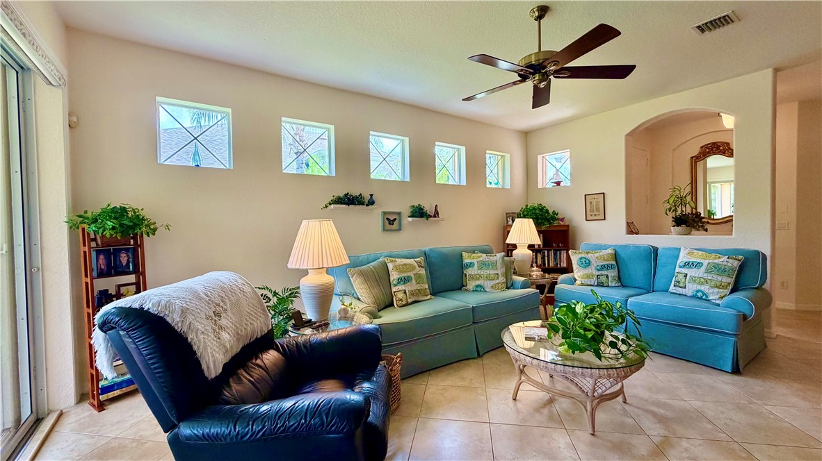 Recessed arched wall feature, ceiling fan, and tiled flooring