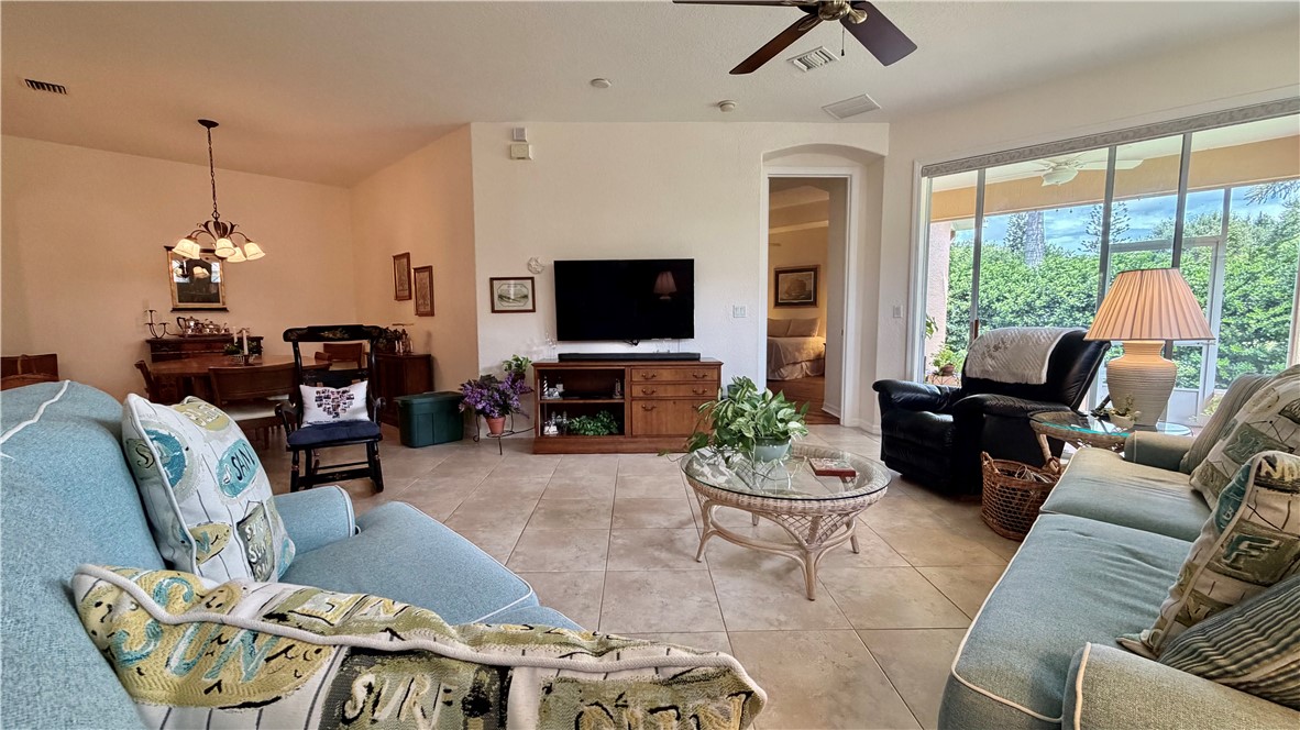 Tiled flooring extending throughout, vaulted ceilings, pendant lighting, and a screened outdoor living space