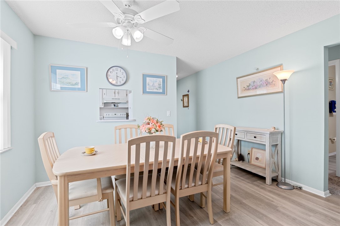 Recessed wall niche, ceiling fan with light fixture, and wood-finish flooring