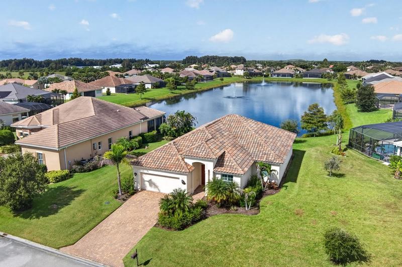 Single-story residence featuring a tile roof, an attached garage, and a paver driveway