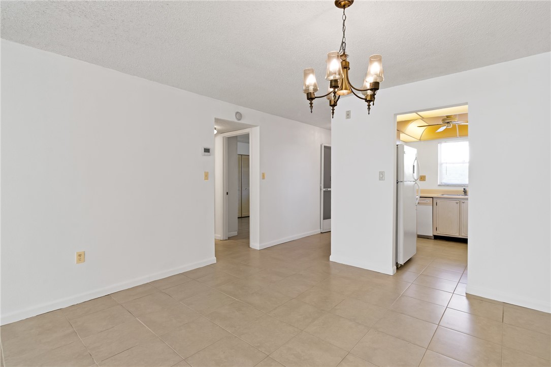 Recessed lighting, tile flooring, and a brass chandelier