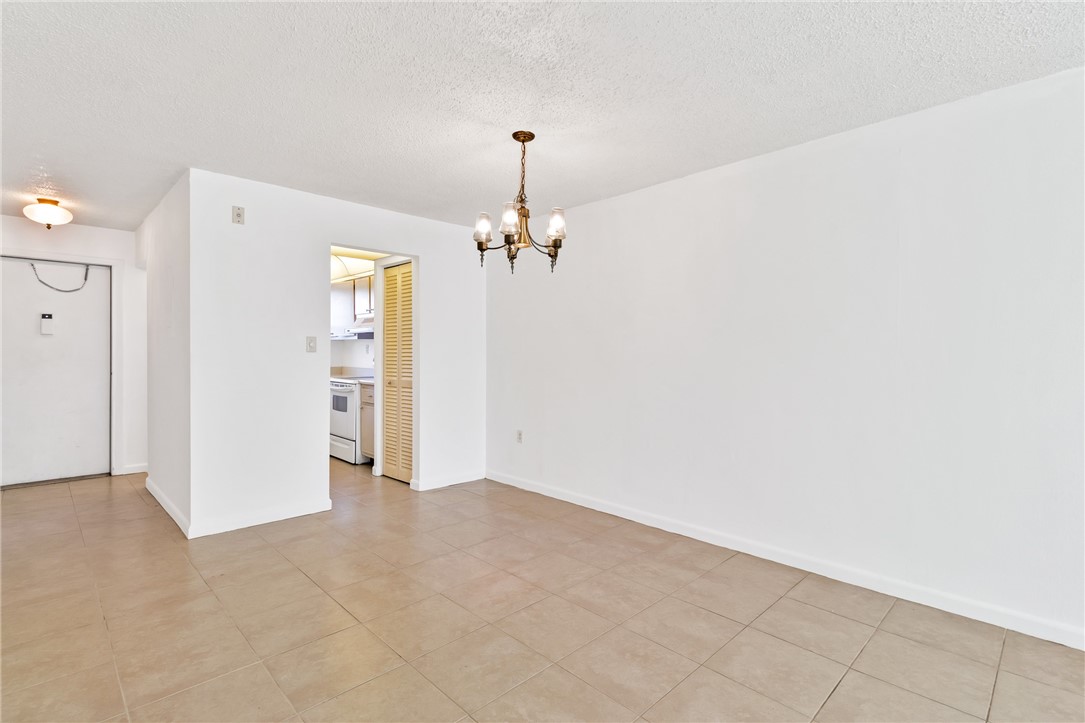 Tile flooring throughout, recessed lighting, and a brass chandelier