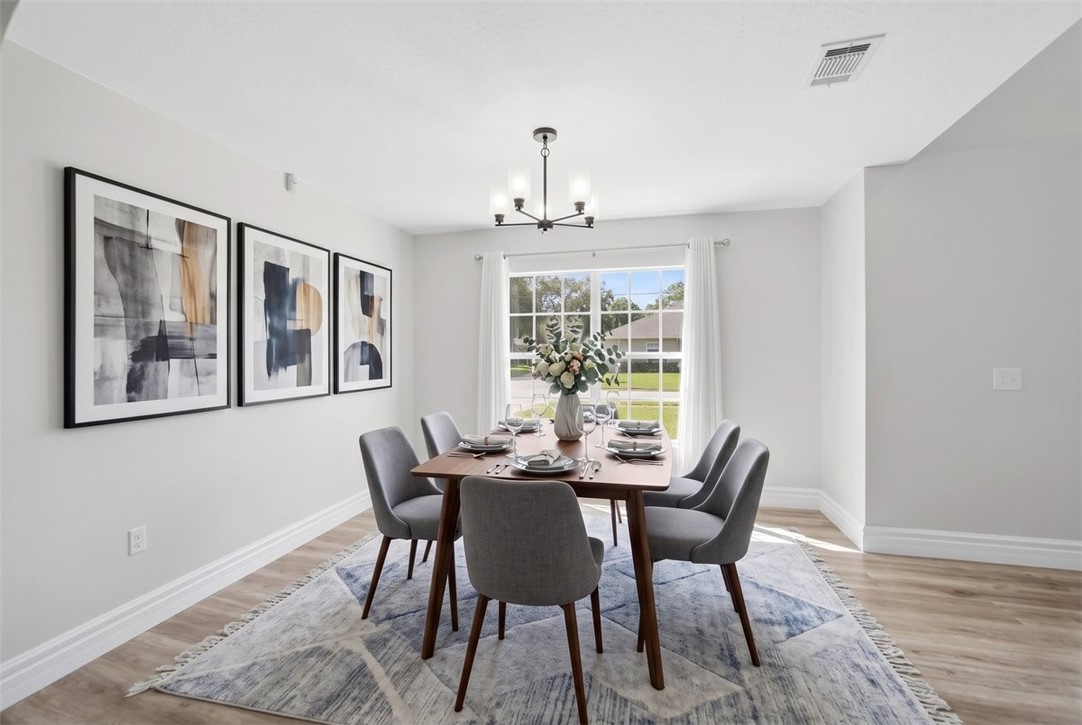 Recessed lighting, wood-finish flooring, white trim, and a multi-pane window
