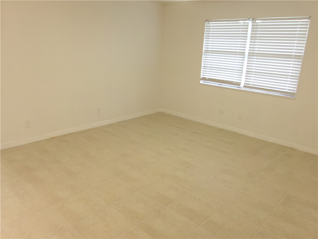 Neutral wall color, ceramic tile flooring, and window with horizontal blinds