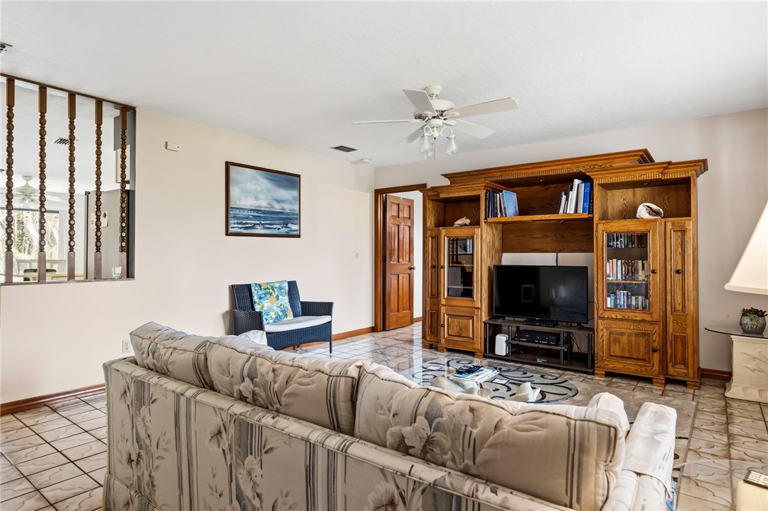 Living area featuring a comprehensive built-in wood entertainment center with integrated shelving and glass-front cabinetry