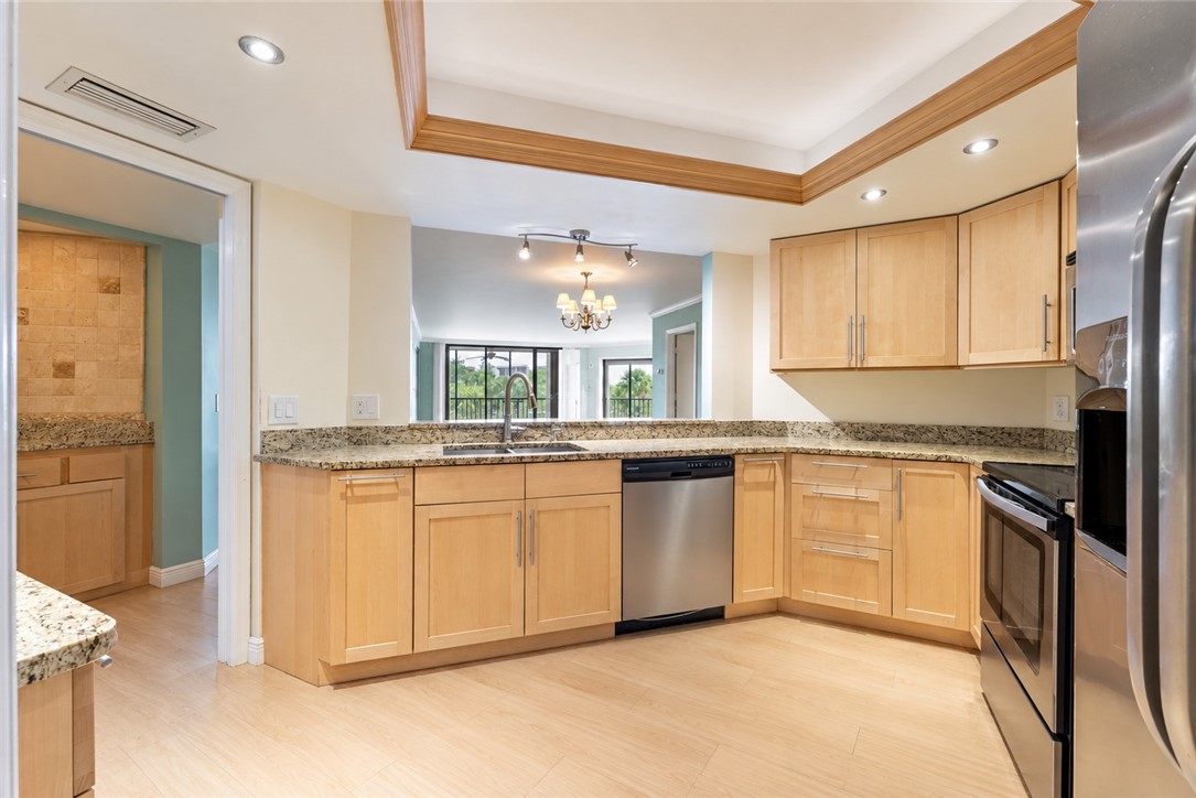 Light wood-finish flooring, recessed lighting, wood cabinetry, granite countertops, and stainless steel appliances