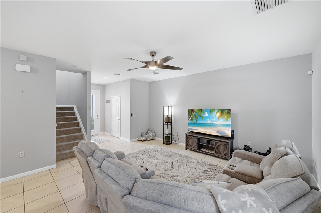 Spacious living area featuring light gray walls and ceramic tile flooring