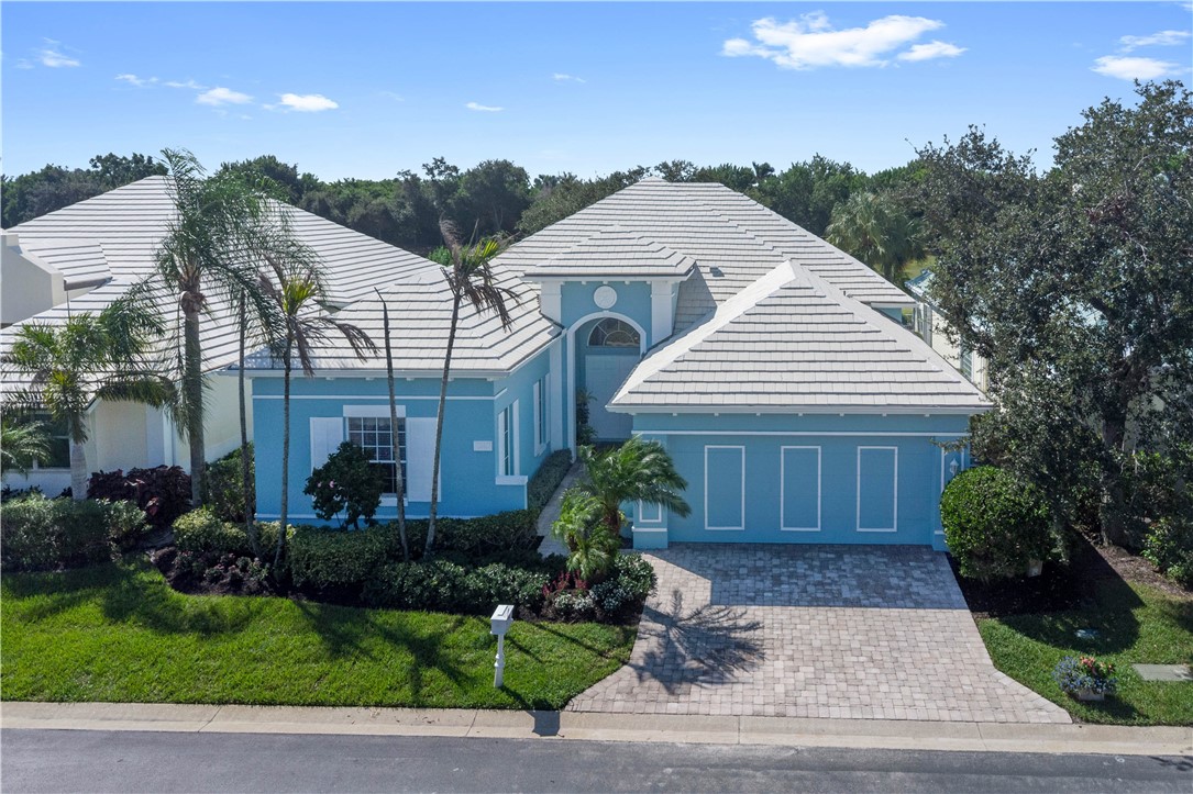 Mediterranean-style residence featuring a tile roof, stucco exterior, and an attached garage with a paved driveway