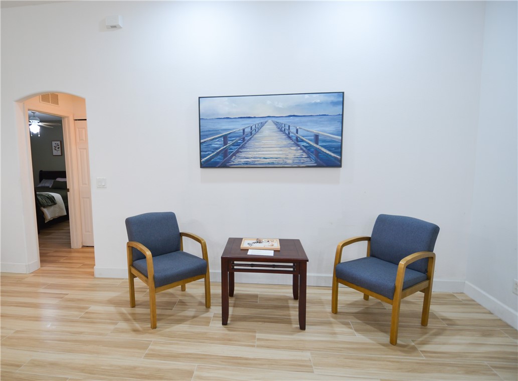 Light-toned wood-finish flooring, white walls, and an arched doorway