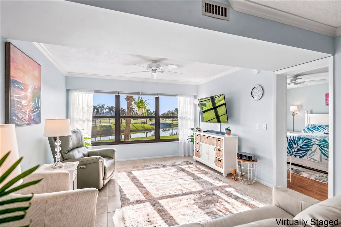Virtually Staged: Expansive living area with large windows, crown molding, and ceiling fan