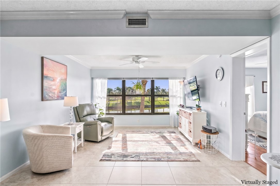 Virtually Staged: Tile flooring, large windows, ceiling fan, crown molding, and an open doorway