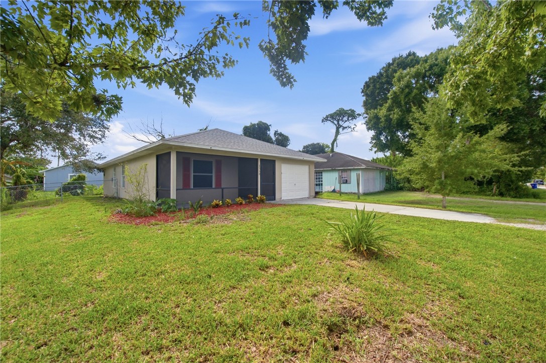 Single-story residence with a screened front porch, red shutters, and an attached garage