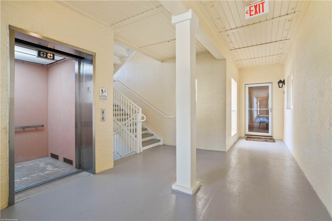 Elevator access, painted wood ceiling, painted flooring, white painted staircase with railing, and exterior door with screen