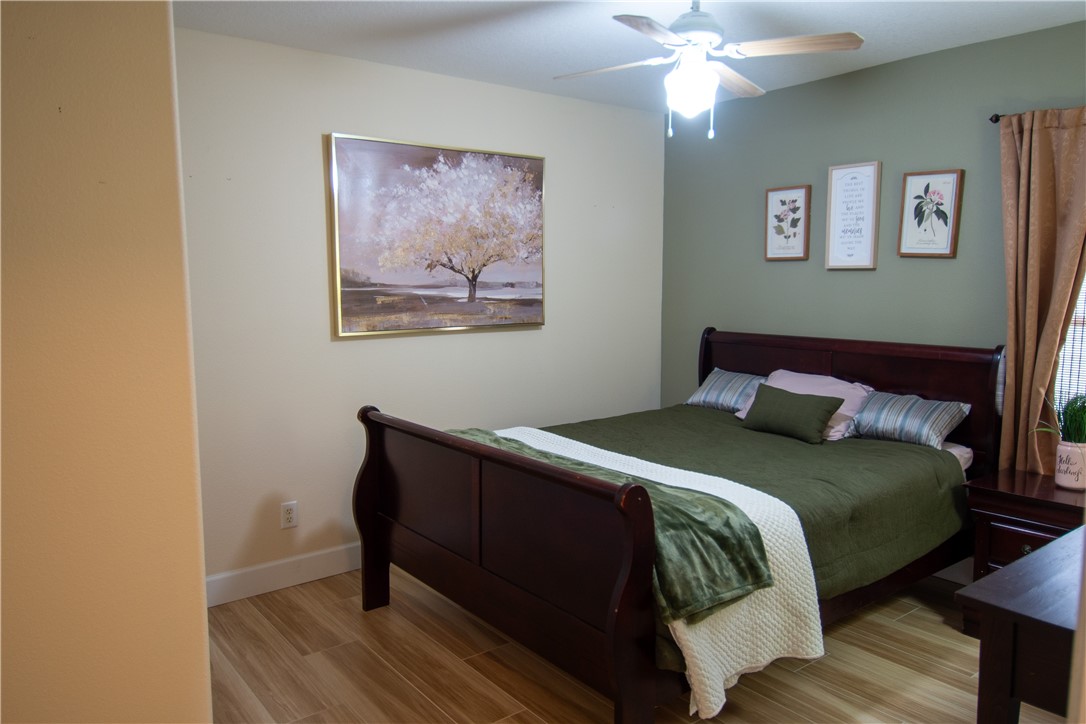 Recessed lighting with a ceiling fan, accent wall, wood-finish flooring, and white trim