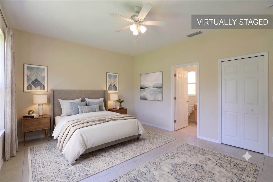 Spacious room featuring neutral tone walls, tile flooring, a ceiling fan with integrated lighting, a double bi-fold closet, and an entry to an additional room