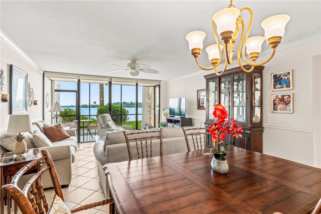 Open-concept living area with water frontage, wall-to-wall glass sliders, and tile flooring