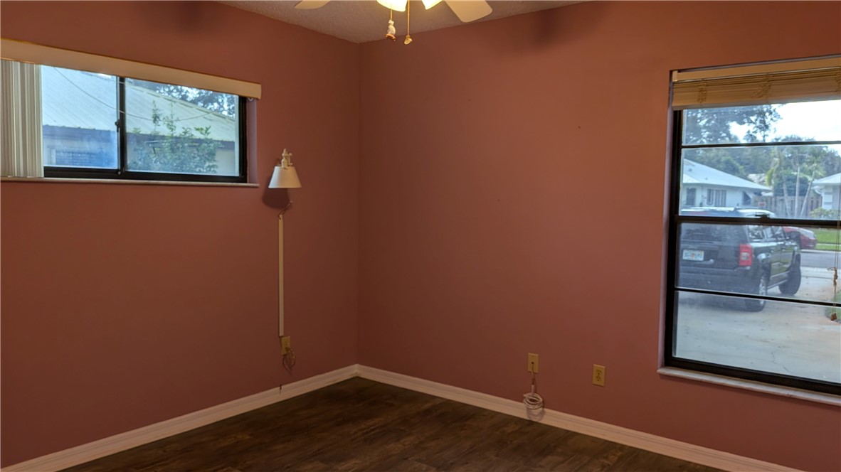 Wood-finish flooring with white trim and multiple windows