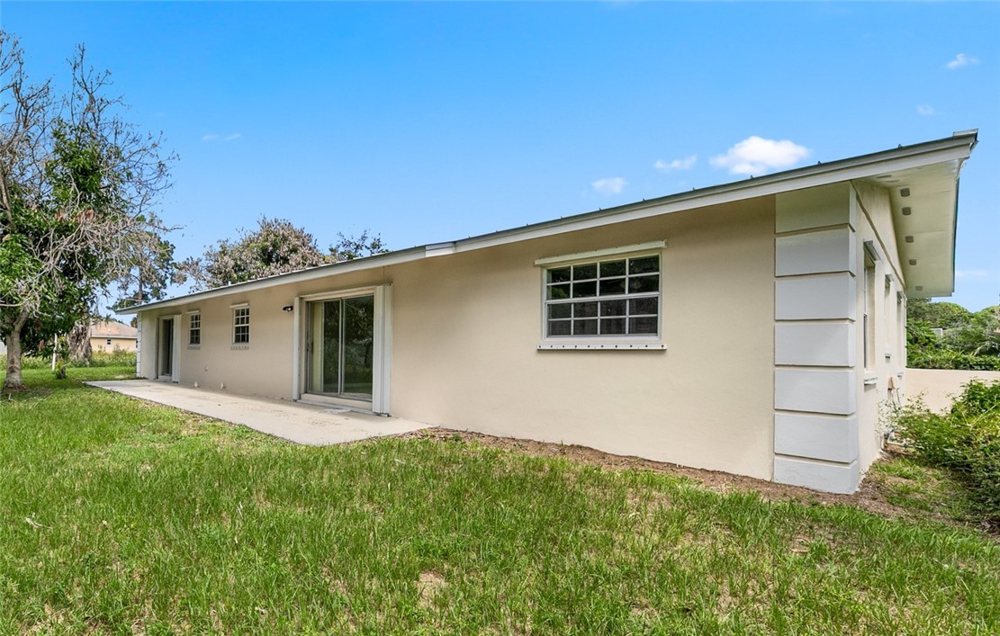 Exterior featuring a stucco finish, multiple windows, a sliding glass door, and a concrete patio