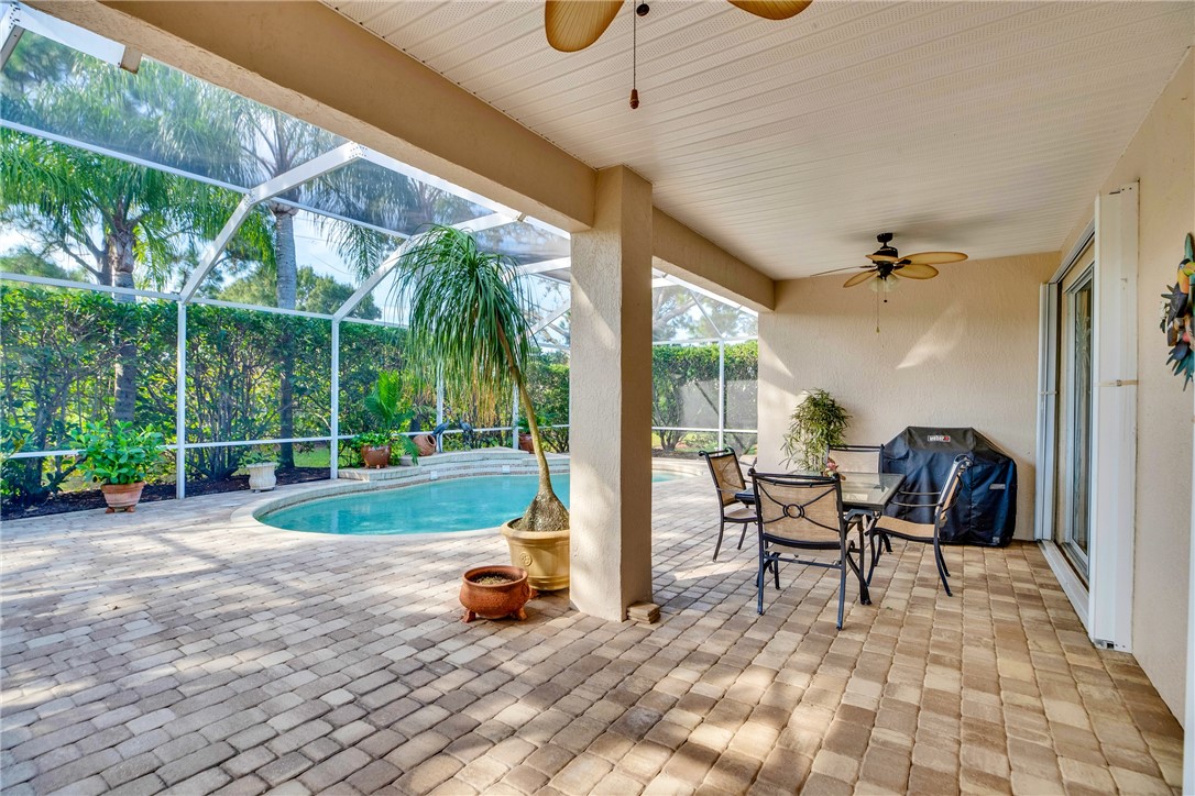 Covered lanai featuring a ceiling fan, direct pool access, and a screened enclosure