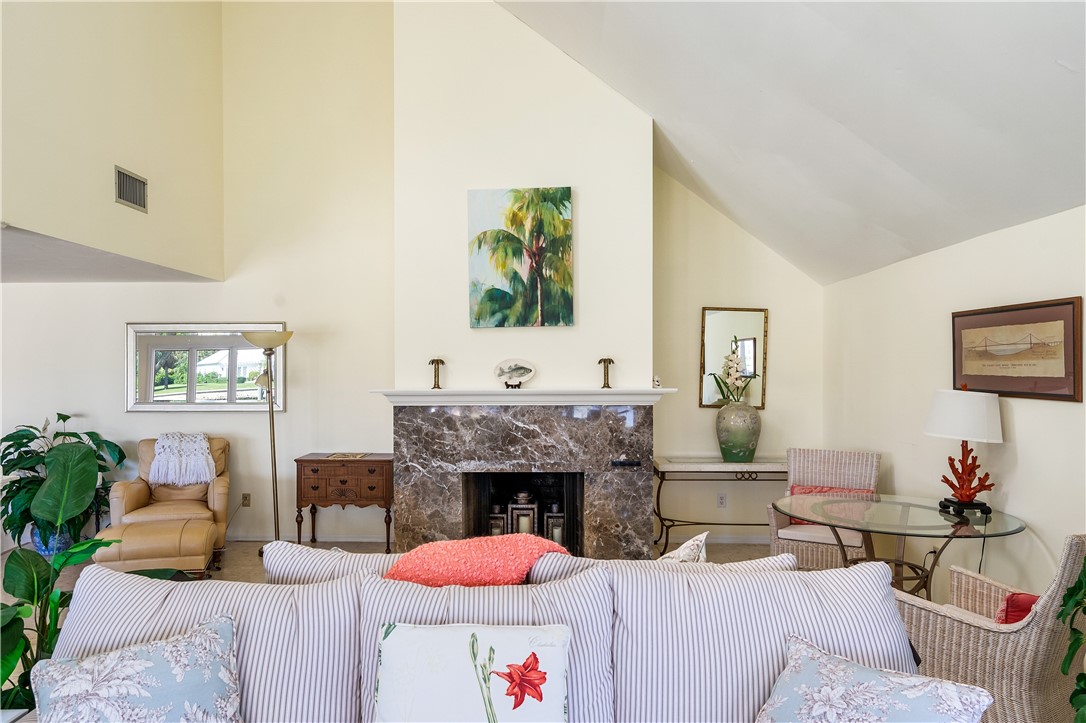 Vaulted ceiling with a marble-clad fireplace and mantel