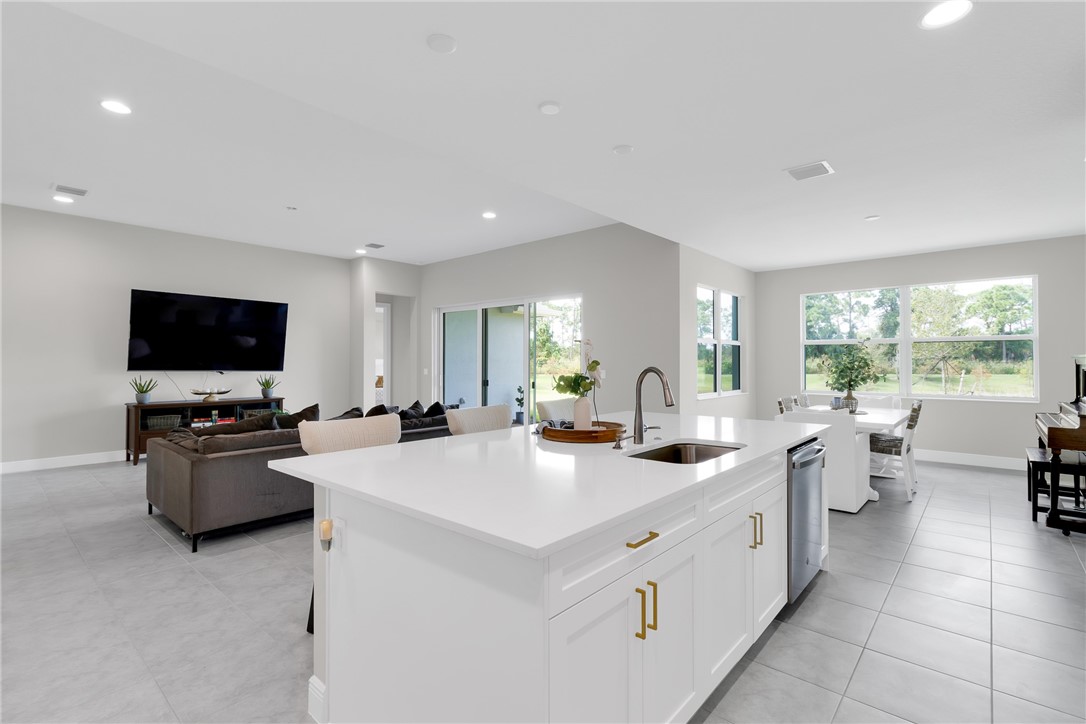 White kitchen island with a built-in sink and stainless steel dishwasher