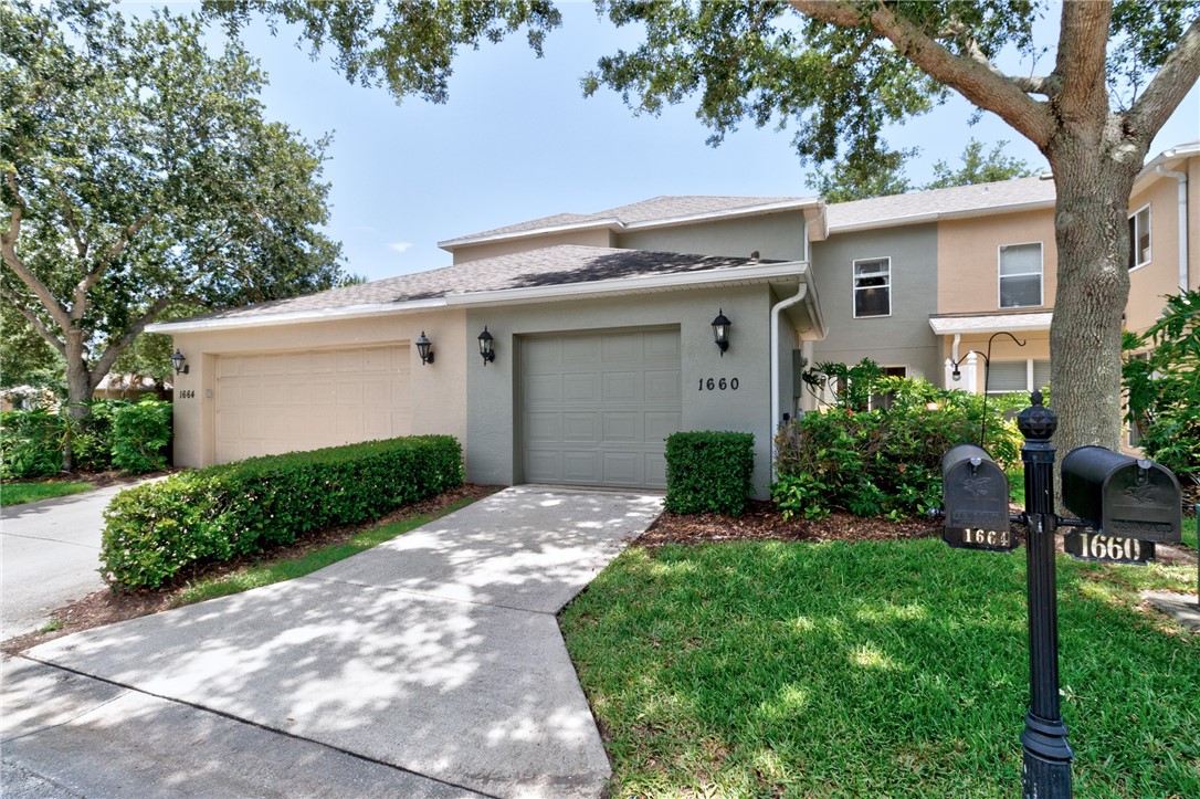 Exterior featuring a one-car garage, concrete driveway, and established landscaping