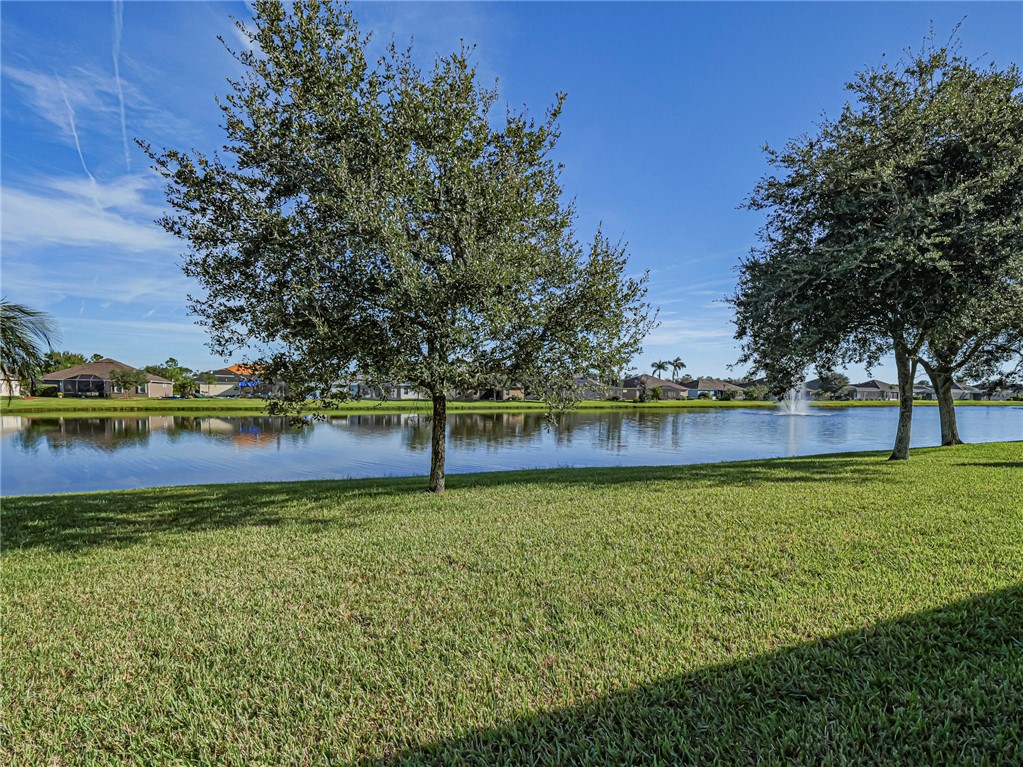 Manicured lawn overlooking a lake with a central fountain feature