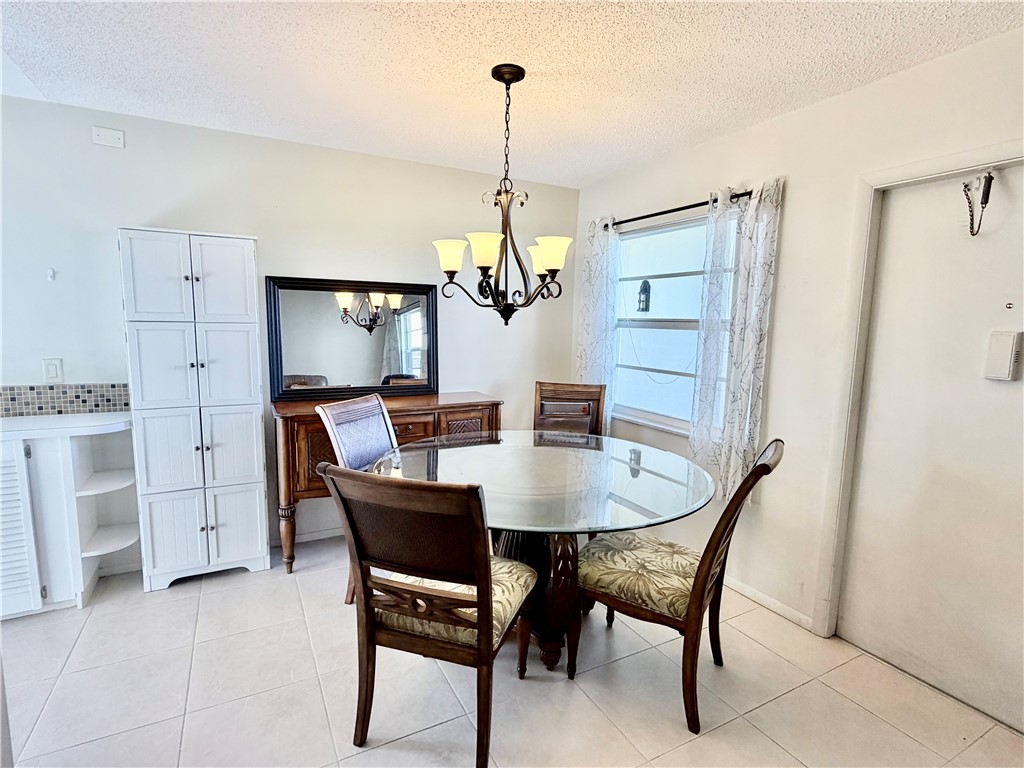 Tiled flooring throughout, recessed window, and overhead chandelier