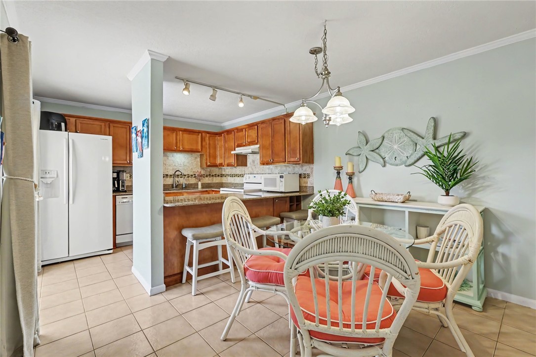 Kitchen with wood-finish cabinetry, tile flooring, and a breakfast bar